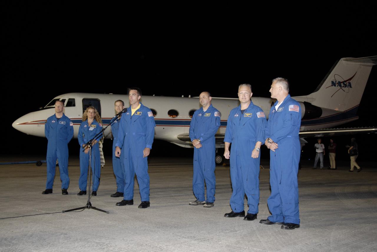 CAPE CANAVERAL, Fla. – At the Shuttle Landing Facility, STS-127 Mission Specialist Christopher Cassidy, at microphone, addresses the media and those on hand to welcome the STS-127 crew to NASA's Kennedy Space Center in Florida. Cassidy and the other members of the crew arrived from Houston aboard the Shuttle Training Aircraft in the background to get ready for launch on space shuttle Endeavour on June 13.  From left are Mission Specialists Tim Kopra, Julie Payette of the Canadian Space Agency, and Tom Marshburn; Mission Specialist Christopher Cassidy; Commander Mark Polansky; Pilot Doug Hurley; and Mission Specialist Dave Wolf.  The STS-127 mission is the final of three flights dedicated to the assembly of the Japan Aerospace Exploration Agency's Kibo laboratory complex on the International Space Station.  Endeavour will deliver the Japanese Experiment Module's Exposed Facility, or JEM-EF, and the Experiment Logistics Module-Exposed Section, or ELM-ES, to the space station on STS-127.  Photo credit: NASA/Kim Shiflett