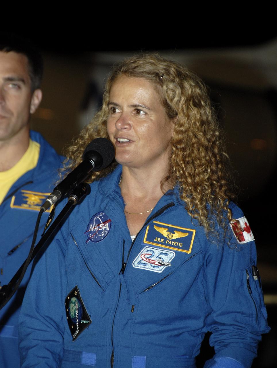 CAPE CANAVERAL, Fla. – At the Shuttle Landing Facility, STS-127 Mission Specialist Julie Payette, at microphone, addresses the media and those on hand to welcome the STS-127 crew to NASA's Kennedy Space Center in Florida, as Mission Specialist Christopher Cassidy looks on.  Payette and the other members of the crew arrived from Houston aboard a Shuttle Training Aircraft to get ready for launch on space shuttle Endeavour on June 13.  Payette represents the Canadian Space Agency and is making her second shuttle flight.  The STS-127 mission is the final of three flights dedicated to the assembly of the Japan Aerospace Exploration Agency's Kibo laboratory complex on the International Space Station.  Endeavour will deliver the Japanese Experiment Module's Exposed Facility, or JEM-EF, and the Experiment Logistics Module-Exposed Section, or ELM-ES, to the space station on STS-127.  Photo credit: NASA/Kim Shiflett