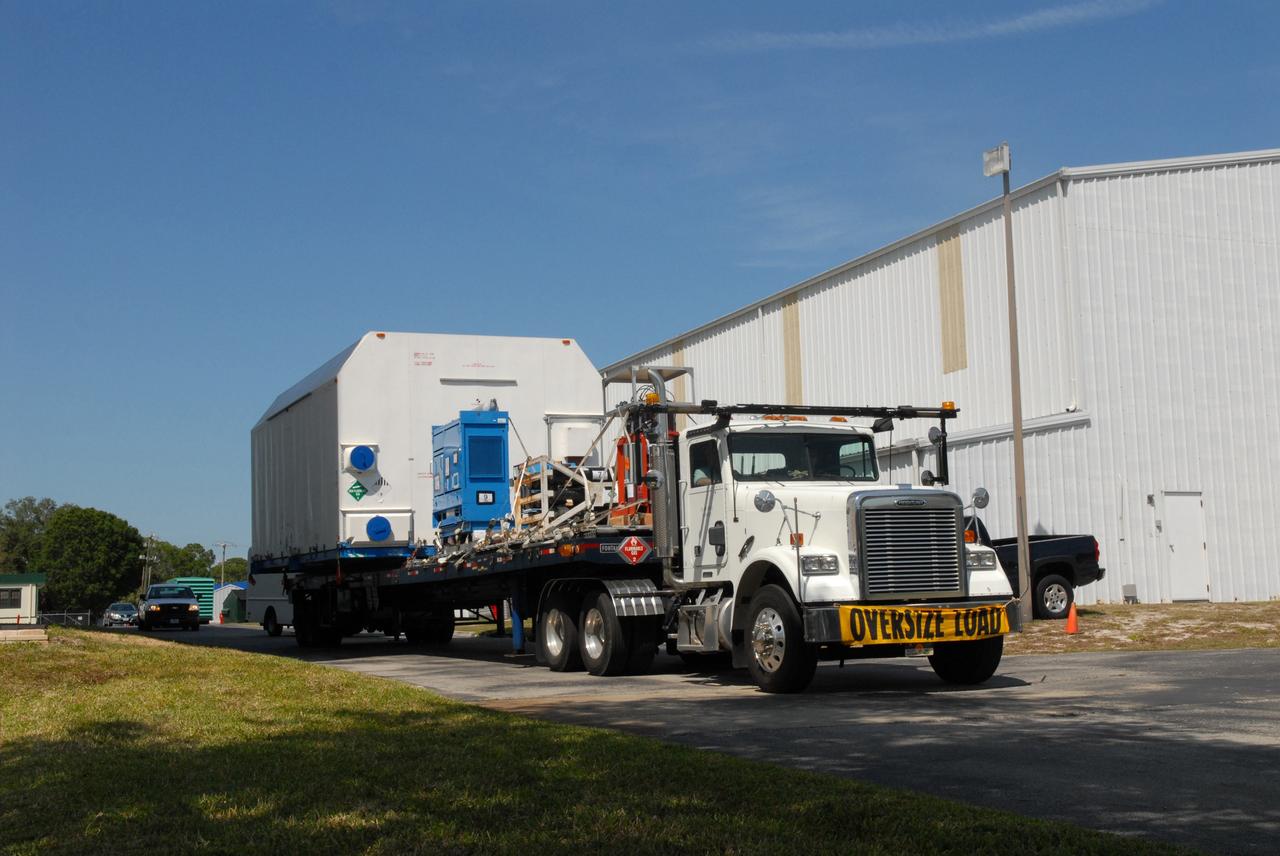 CAPE CANAVERAL, Fla. –  A flatbed truck carrying the STSS Demonstrator SV-2spacecraft arrives at the Astrotech payload processing facility in Titusville, Fla.  The spacecraft is a midcourse tracking technology demonstrator, part of an evolving ballistic missile defense system. STSS is capable of tracking objects after boost phase and provides trajectory information to other sensors. It will be launched by NASA for the Missile Defense Agency in late summer.  Photo credit: NASA/Jack Pfaller  (Approved for Public Release 09-MDA-4616 [27 May 09])
