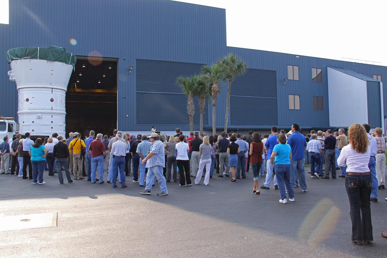 CAPE CANAVERAL, Fla. – At NASA's Kennedy Space Center in Florida, employees gather to watch the Ares I-X forward assembly (comprising the frustum, forward skirt extension and forward skirt) as it moves out of the Assembly and Refurbishment Facility. The assembly is being transferred to the Vehicle Assembly Building's High Bay 4 for processing and stacking to the upper stage. Ares I-X is the flight test for the Ares I which will provide NASA an early opportunity to test and prove hardware, facilities and ground operations associated with Ares I, which is part of the Constellation Program to return men to the moon and beyond. Launch of the Ares I-X flight test is targeted for August 2009. Photo credit: NASA/Jack Pfaller