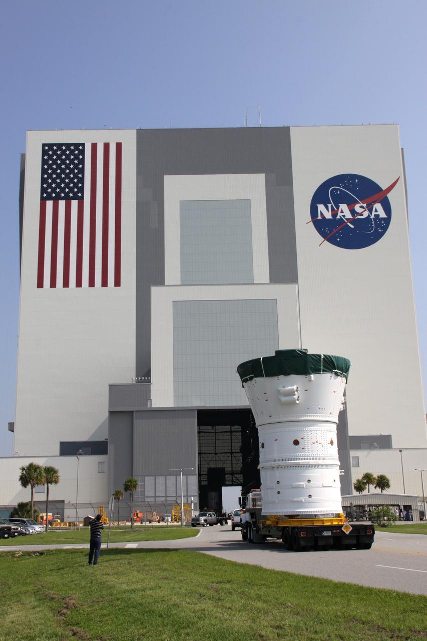 CAPE CANAVERAL, Fla. –  At NASA's Kennedy Space Center in Florida, the Ares I-X forward assembly comprising the frustum, forward skirt extension and forward skirt heads for the Vehicle Assembly Building, in the background.  In the VAB's High Bay 4, the forward assembly will undergo processing and stacking to the upper stage. Ares I-X is the flight test for the Ares I which will provide NASA an early opportunity to test and prove hardware, facilities and ground operations associated with Ares I, which is part of the Constellation Program to return men to the moon and beyond. Launch of the Ares I-X flight test is targeted for August 2009.   Photo credit: NASA/Jack Pfaller