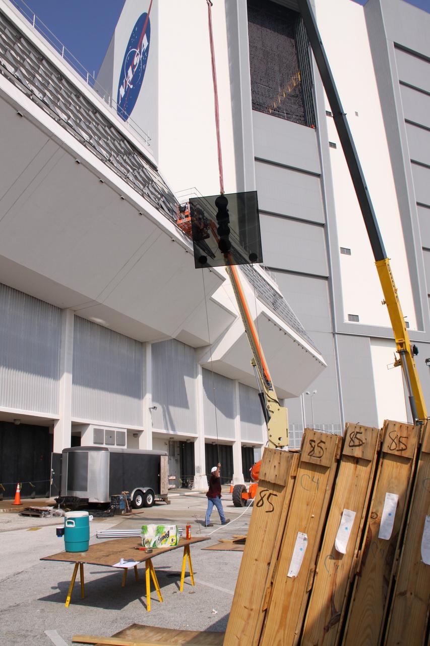 CAPE CANAVERAL, Fla. –  A new window is raised toward the existing Firing Room windows in the Launch Control Center at NASA's Kennedy Space Center in Florida.  New, hurricane-rated window systems for the four Firing Rooms and the vestibule areas between Firing Rooms 1 & 2 and Firing Rooms 3 & 4 are being installed. In order to avoid operational impacts the new windows are being installed on the outside of the existing windows, enclosing the space formerly occupied by the louvers.  The old windows will remain in place until the new windows are completely installed and leak tested. This approach will continue to keep the firing rooms from being exposed to the elements.   Photo credit: NASA/Jack Pfaller