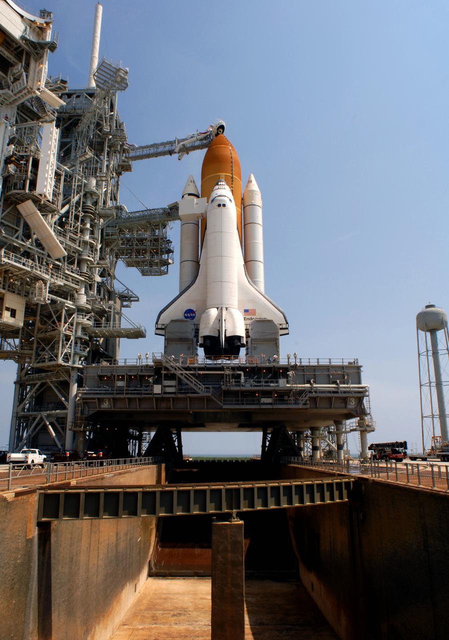 CAPE CANAVERAL, Fla. – On Launch Pad 39A at NASA's Kennedy Space Center in Florida, space shuttle Endeavour is revealed after the rollback of the rotating service structure, or RSS. In the foreground is the flame trench, which the mobile launcher platform straddles. On top of the external fuel tank is the oxygen vent hood, called the "beanie cap," which is designed to vent gaseous oxygen vapors away from the shuttle. The rollback is preparation for Endeavour's liftoff June 13 on the STS-127 mission with a crew of seven. First motion was at 10:39 a.m. EDT and completed at 11:18 a.m. The rotating structure provides protected access to the shuttle for changeout and servicing of payloads at the pad. It is supported by a rotating bridge that pivots on a vertical axis on the west side of the pad's flame trench. After the RSS is rolled back, the orbiter is ready for fuel cell activation and external tank cryogenic propellant loading operations. The launch will be Endeavour's 23rd flight. The shuttle will carry the Japanese Experiment Module's Exposed Facility, or JEM-EF, and the Experiment Logistics Module-Exposed Section, or ELM-ES, on STS-127. The mission is the final of three flights dedicated to the assembly of the Japan Aerospace Exploration Agency's Kibo laboratory complex on the space station. Endeavour's launch is scheduled for June 13 at 7:17 a.m. EDT. Photo credit: NASA/Jim Grossmann