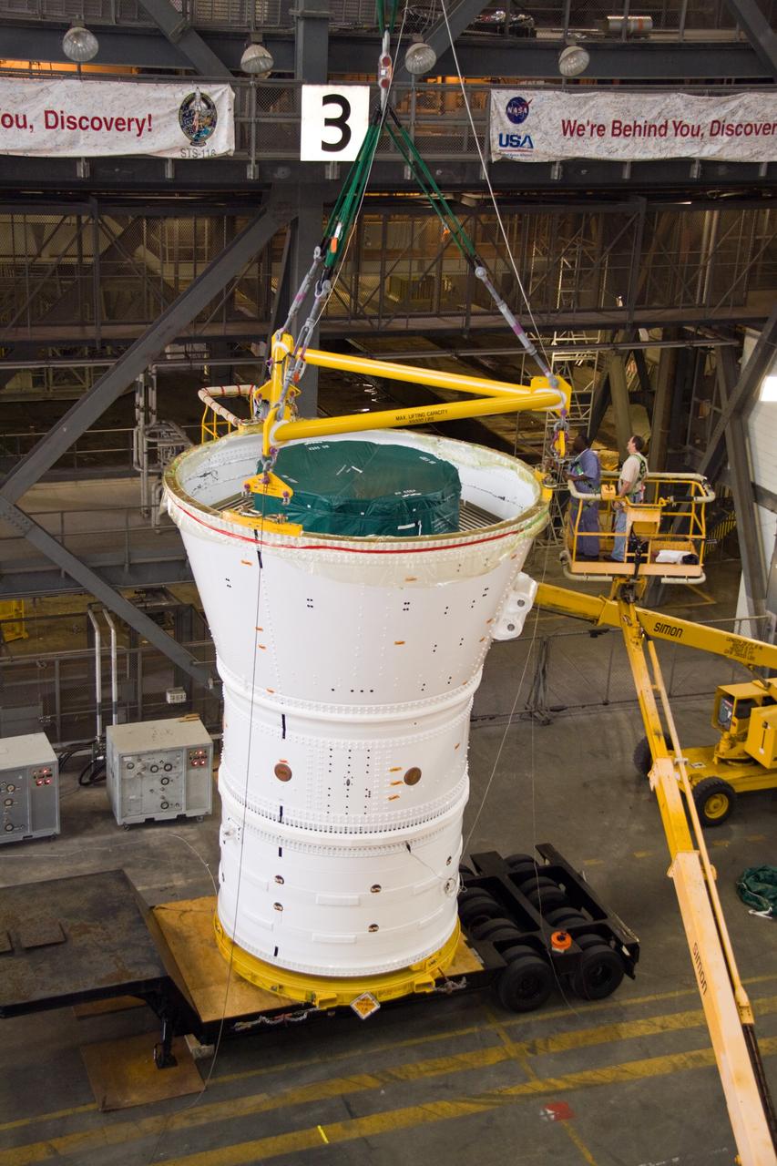 CAPE CANAVERAL, Fla. – In the Vehicle Assembly Building's transfer aisle at NASA's Kennedy Space Center in Florida, a crane is attached to the Ares I-X forward assembly. The assembly will be lifted from the trailer and placed on a stand in preparation for being moved into High Bay 4. Ares I-X is the flight test vehicle for the Ares I, a component of the Constellation Program. Ares I is the essential core of a safe, reliable, cost-effective space transportation system that eventually will carry crewed missions back to the moon, on to Mars and out into the solar system. The launch of the Ares I-X flight test is targeted for August 2009. Photo credit: NASA/Jack Pfaller