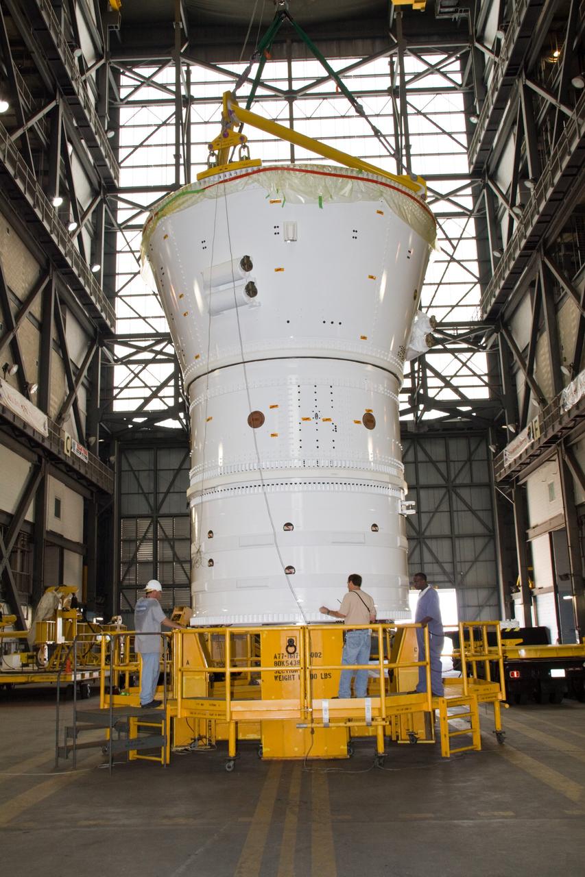 CAPE CANAVERAL, Fla. – In the Vehicle Assembly Building's transfer aisle at NASA's Kennedy Space Center in Florida, a crane lowers the Ares I-X forward assembly onto a stand in preparation for being moved into High Bay 4. Ares I-X is the flight test vehicle for the Ares I, a component of the Constellation Program. Ares I is the essential core of a safe, reliable, cost-effective space transportation system that eventually will carry crewed missions back to the moon, on to Mars and out into the solar system. The launch of the Ares I-X flight test is targeted for August 2009. Photo credit: NASA/Jack Pfaller