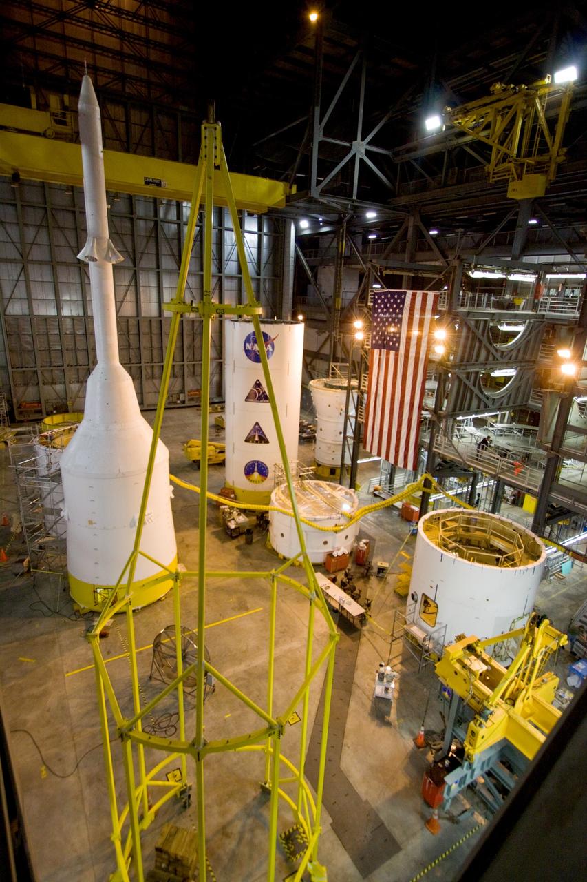 CAPE CANAVERAL, Fla. –  Ares I-X segments and stacks are filling the floor of the Vehicle Assembly Building's High Bay 4 at NASA's Kennedy Space Center in Florida.  At left in the background is the crew module-launch abort system, or CM-LAS, and simulator service module-service adapter stack.  At left in front is the "birdcage," the special crane that will lift the stack.  Not seen is the forward assembly that has joined the other segments. Ares I-X is the flight test vehicle for the Ares I, a component of the Constellation Program. Ares I is the essential core of a safe, reliable, cost-effective space transportation system that eventually will carry crewed missions back to the moon, on to Mars and out into the solar system. The launch of the Ares I-X flight test is targeted for August 2009. Photo credit: NASA/Jack Pfaller