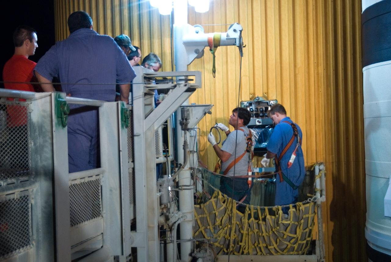 CAPE CANAVERAL, Fla. – On Launch Pad 39A at NASA's Kennedy Space Center in Florida, workers at right repair the Ground Umbilical Carrier Plate, or GUCP. A leak of hydrogen at the location during tanking June 12 for the STS-127 mission caused the mission to be scrubbed at 12:26 a.m. June 13. The GUCP is the overboard vent to the pad and the flare stack where the vented hydrogen is burned off. Endeavour is scheduled to launch on its STS-127 mission on June 17 at 5:40 a.m. EDT. Photo credit: NASA/Tim Jacobs