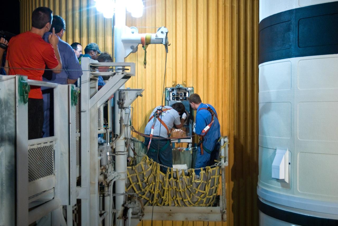 CAPE CANAVERAL, Fla. – On Launch Pad 39A at NASA's Kennedy Space Center in Florida, workers at right repair the Ground Umbilical Carrier Plate, or GUCP. A leak of hydrogen at the location during tanking June 12 for the STS-127 mission caused the mission to be scrubbed at 12:26 a.m. June 13. The GUCP is the overboard vent to the pad and the flare stack where the vented hydrogen is burned off. Endeavour is scheduled to launch on its STS-127 mission on June 17 at 5:40 a.m. EDT. Photo credit: NASA/Tim Jacobs