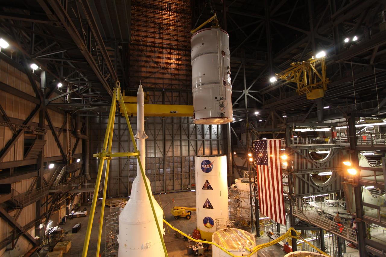 CAPE CANAVERAL, Fla. –  In the Vehicle Assembly Building at NASA's Kennedy Space Center in Florida, the Ares I-X fifth segment simulator assembly is lowered into High Bay 4 where other Ares I-X segments are located.  Ares I-X is the flight test vehicle for the Ares I,  the essential core of a safe, reliable, cost-effective space transportation system that eventually will carry crewed missions back to the moon, on to Mars and out into the solar system. Ares I-X is targeted for launch in August 2009.   Photo credit: NASA/Kim Shiflett