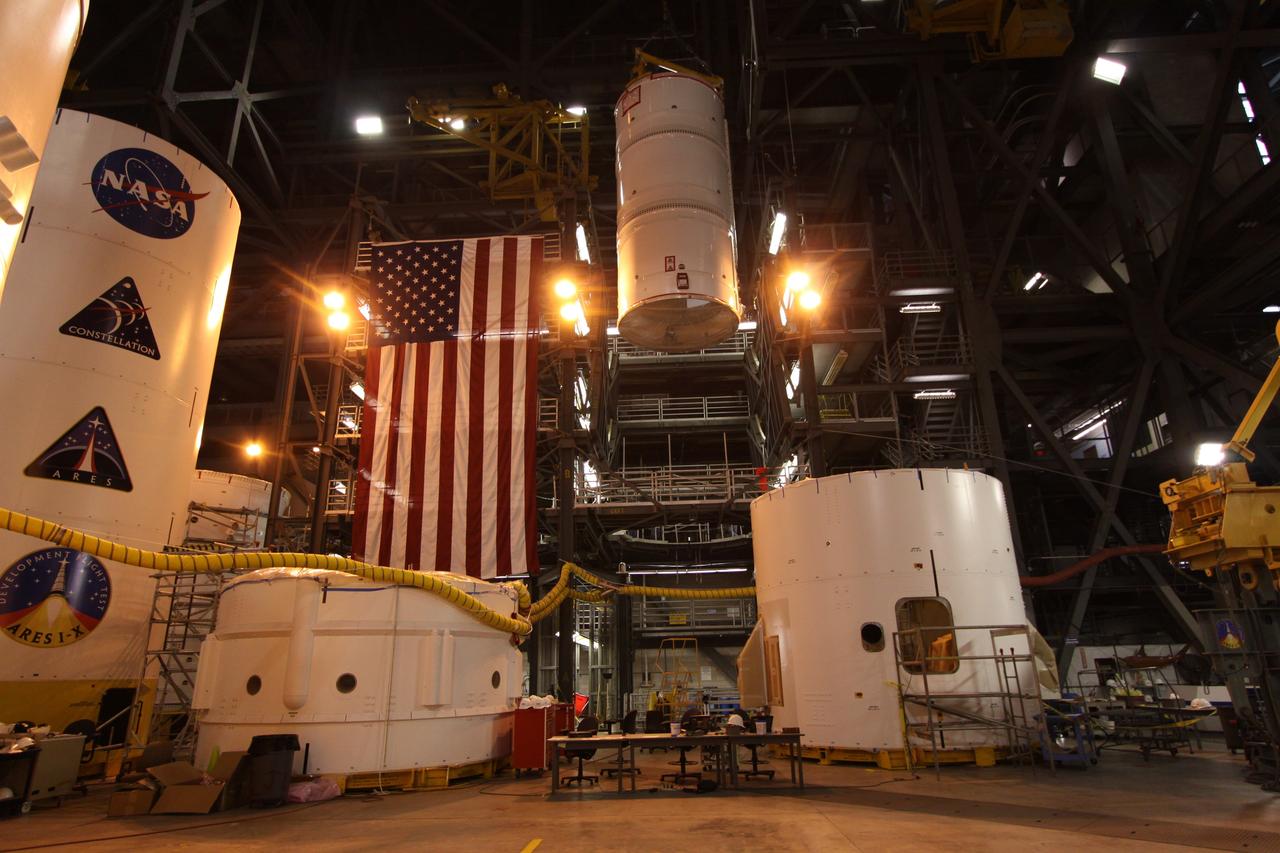 CAPE CANAVERAL, Fla. –  In the Vehicle Assembly Building at NASA's Kennedy Space Center in Florida, the Ares I-X fifth segment simulator assembly is lowered into High Bay 4 where other Ares I-X segments are located. Ares I-X is the flight test vehicle for the Ares I,  the essential core of a safe, reliable, cost-effective space transportation system that eventually will carry crewed missions back to the moon, on to Mars and out into the solar system. Ares I-X is targeted for launch in August 2009.   Photo credit: NASA/Kim Shiflett
