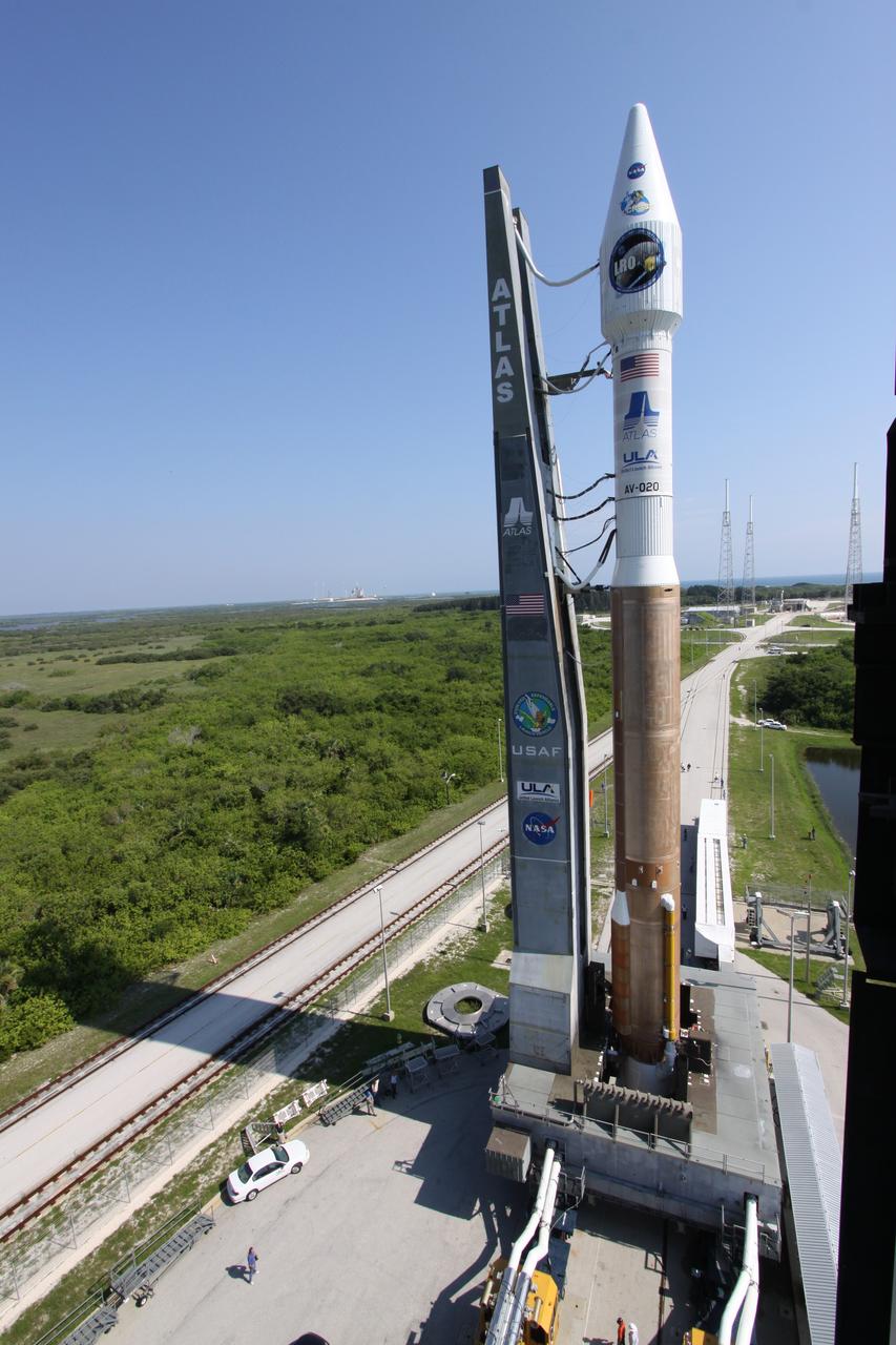 CAPE CANAVERAL, Fla. –   On Launch Complex-41 on Cape Canaveral Air Force Station in Florida, NASA's Lunar Reconnaissance Orbiter, or LRO, and NASA's Lunar Crater Observation and Sensing Satellite, known as LCROSS, are attached to the gantry at left as they roll out to the launch pad.  They are atop their launch vehicle, the Atlas V/Centaur rocket.  LRO and LCROSS are the first missions in NASA's plan to return humans to the moon and begin establishing a lunar outpost by 2020. The LRO also includes seven instruments that will help NASA characterize the moon's surface:  DIVINER, LAMP, LEND, LOLA, CRATER, Mini-RF and LROC. Launch is scheduled for 5:22 p.m. EDT June 18 . Photo credit: NASA/Jack Pfaller