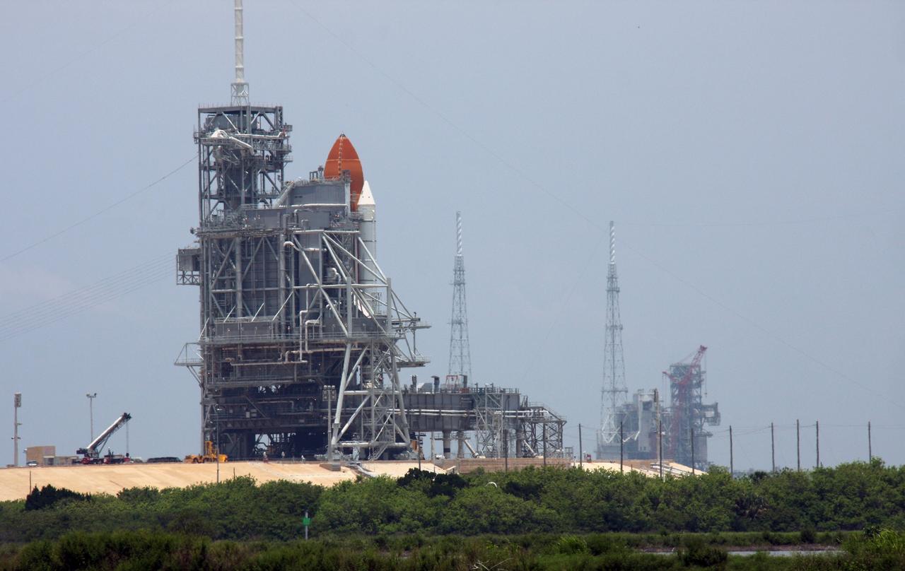 CAPE CANAVERAL, Fla. – The rotating service structure is closed around space shuttle Endeavour on Launch Pad 39A at NASA's Kennedy Space Center in Florida after its launch for the STS-127 mission was scrubbed at 1:55 a.m. EDT June 17 due to a gaseous hydrogen leak at the Ground Umbilical Carrier Plate. Endeavour’s next launch attempt for the mission is targeted for July 11 at 7:39 p.m. EDT. At right in the background is Launch Pad 39B, surrounded by lightning towers, which will be used for the Constellation Program. Photo credit: NASA/Ken Thornsley