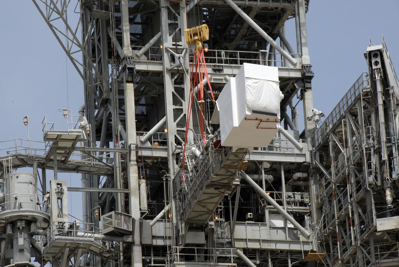 CAPE CANAVERAL, Fla. – The slings from a large crane are being attached to the orbiter access arm, which ends in the White Room, that is part of the fixed service structure, or FSS, on Launch Pad 39B at NASA's Kennedy Space Center in Florida. The White Room provided entry into space shuttles that were on the pad. The arm is being removed from the FSS for the pad's conversion as launch site for the Constellation Program's Ares I-X. The launch of the Ares I-X flight test is targeted for August 2009. Photo credit: NASA/Kim Shiflett