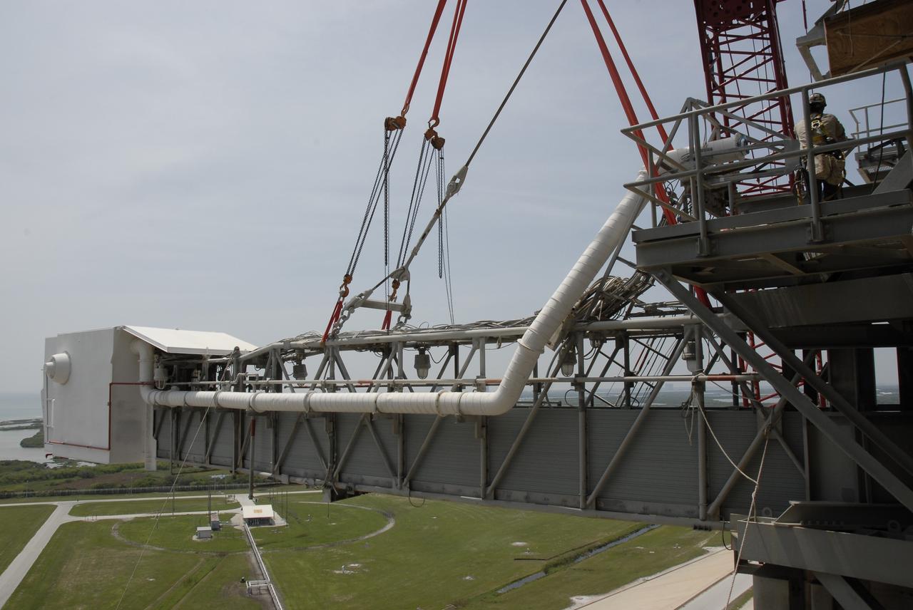 CAPE CANAVERAL, Fla. – The slings from a large crane are in place on the orbiter access arm, which ends in the White Room, that is part of the fixed service structure, or FSS, on Launch Pad 39B at NASA's Kennedy Space Center in Florida. The White Room provided entry into space shuttles that were on the pad. The arm is being removed from the FSS for the pad's conversion as launch site for the Constellation Program's Ares I-X. The launch of the Ares I-X flight test is targeted for August 2009. Photo credit: NASA/Kim Shiflett