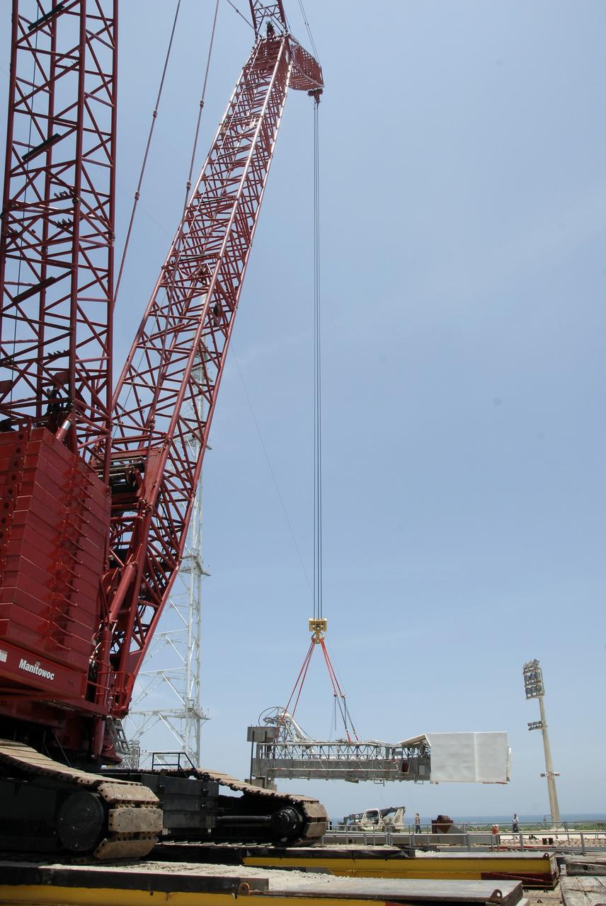 CAPE CANAVERAL, Fla. – On Launch Pad 39B at NASA's Kennedy Space Center in Florida, the crane lowers the orbiter access arm, which ends in the White Room, toward the ground. The arm is being removed from the FSS for the pad's conversion as launch site for the Constellation Program's Ares I-X. The launch of the Ares I-X flight test is targeted for August 2009. Photo credit: NASA/Kim Shiflett