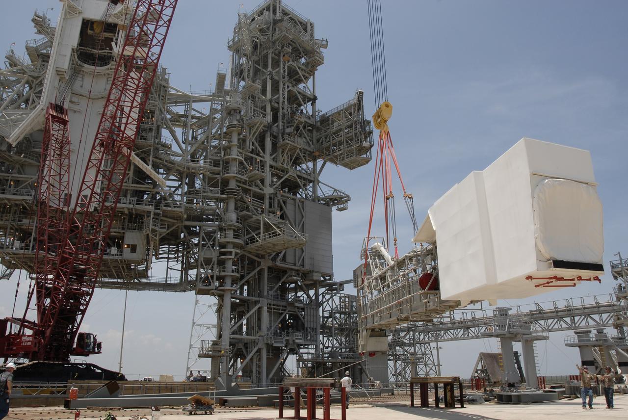 CAPE CANAVERAL, Fla. – On Launch Pad 39B at NASA's Kennedy Space Center in Florida, the crane lowers the orbiter access arm, which ends in the White Room, toward the ground. The arm is being removed from the FSS for the pad's conversion as launch site for the Constellation Program's Ares I-X. The launch of the Ares I-X flight test is targeted for August 2009. Photo credit: NASA/Kim Shiflett