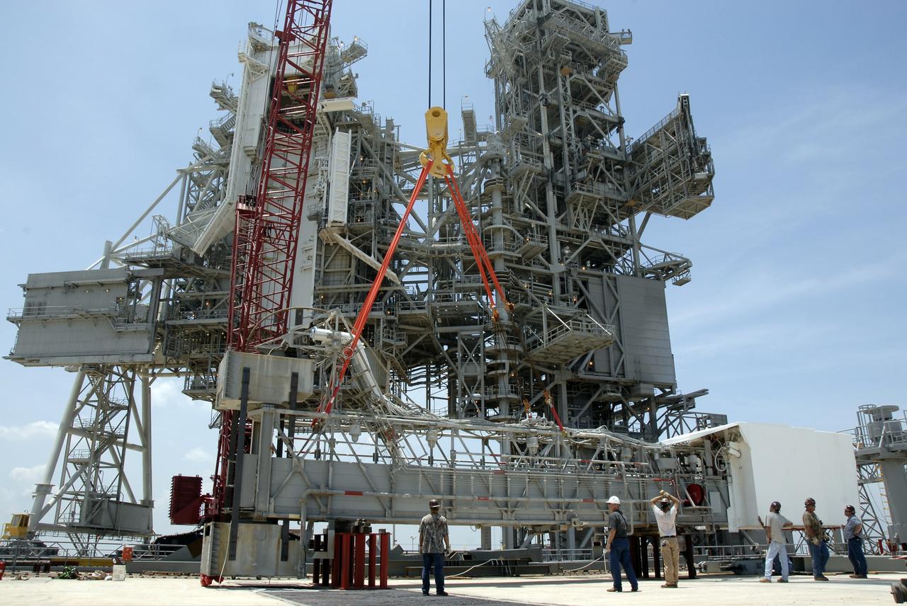 CAPE CANAVERAL, Fla. – On Launch Pad 39B at NASA's Kennedy Space Center in Florida, the crane lowers the orbiter access arm, which ends in the White Room, toward the ground. The arm is being removed from the FSS for the pad's conversion as launch site for the Constellation Program's Ares I-X. The launch of the Ares I-X flight test is targeted for August 2009. Photo credit: NASA/Kim Shiflett
