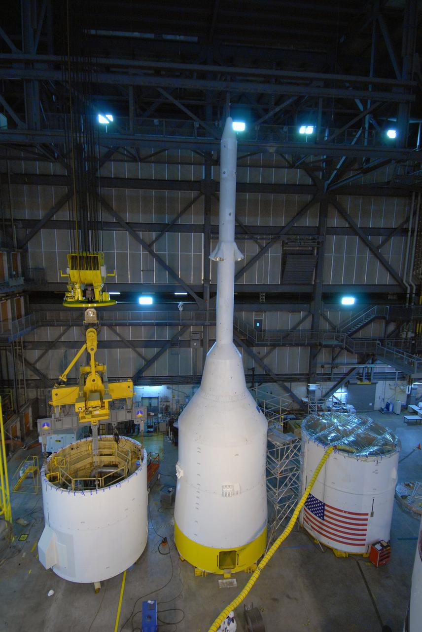 CAPE CANAVERAL, Fla. – In the Vehicle Assembly Building's High Bay 4 at NASA's Kennedy Space Center in Florida, the Ares I-X interstage 1 for the upper stage simulator (left) is being lifted to move it to the forward assembly.  The interstage will be mated with the frustum on the forward assembly.  At center is the crew module-launch abort system, or CM-LAS, and simulator service module-service adapter stack. Ares I-X is the flight test vehicle for the Ares I, a component of the Constellation Program. Ares I is the essential core of a safe, reliable, cost-effective space transportation system that eventually will carry crewed missions back to the moon, on to Mars and out into the solar system.  Ares I-X is targeted for launch in August 2009.  Photo credit: NASA/Tim Jacobs