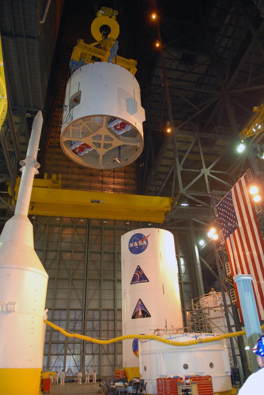 CAPE CANAVERAL, Fla. – In the Vehicle Assembly Building's High Bay 4 at NASA's Kennedy Space Center in Florida, the Ares I-X interstage 1 for the upper stage simulator is being moved to the forward assembly.  The interstage will be mated with the frustum on the forward assembly.  To the left is the crew module-launch abort system, or CM-LAS, and simulator service module-service adapter stack. Ares I-X is the flight test vehicle for the Ares I, a component of the Constellation Program. Ares I is the essential core of a safe, reliable, cost-effective space transportation system that eventually will carry crewed missions back to the moon, on to Mars and out into the solar system.  Ares I-X is targeted for launch in August 2009.  Photo credit: NASA/Tim Jacobs