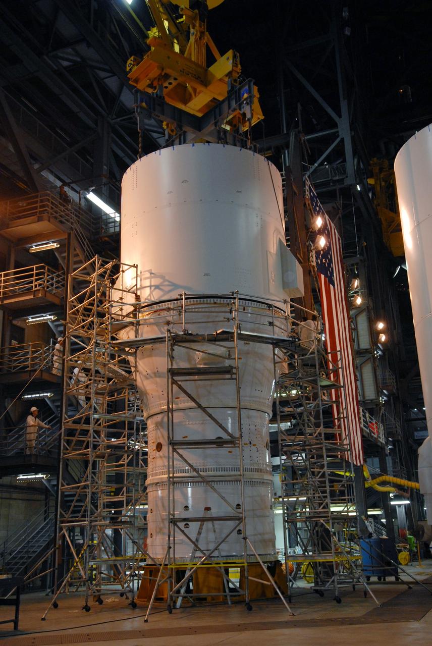 CAPE CANAVERAL, Fla. – In the Vehicle Assembly Building's High Bay 4 at NASA's Kennedy Space Center in Florida, the Ares I-X interstage 1 for the upper stage simulator is  lowered onto the forward assembly.  It will be mated with the frustum on top of the forward assembly. Ares I-X is the flight test vehicle for the Ares I, a component of the Constellation Program. Ares I is the essential core of a safe, reliable, cost-effective space transportation system that eventually will carry crewed missions back to the moon, on to Mars and out into the solar system.  Ares I-X is targeted for launch in August 2009.  Photo credit: NASA/Tim Jacobs
