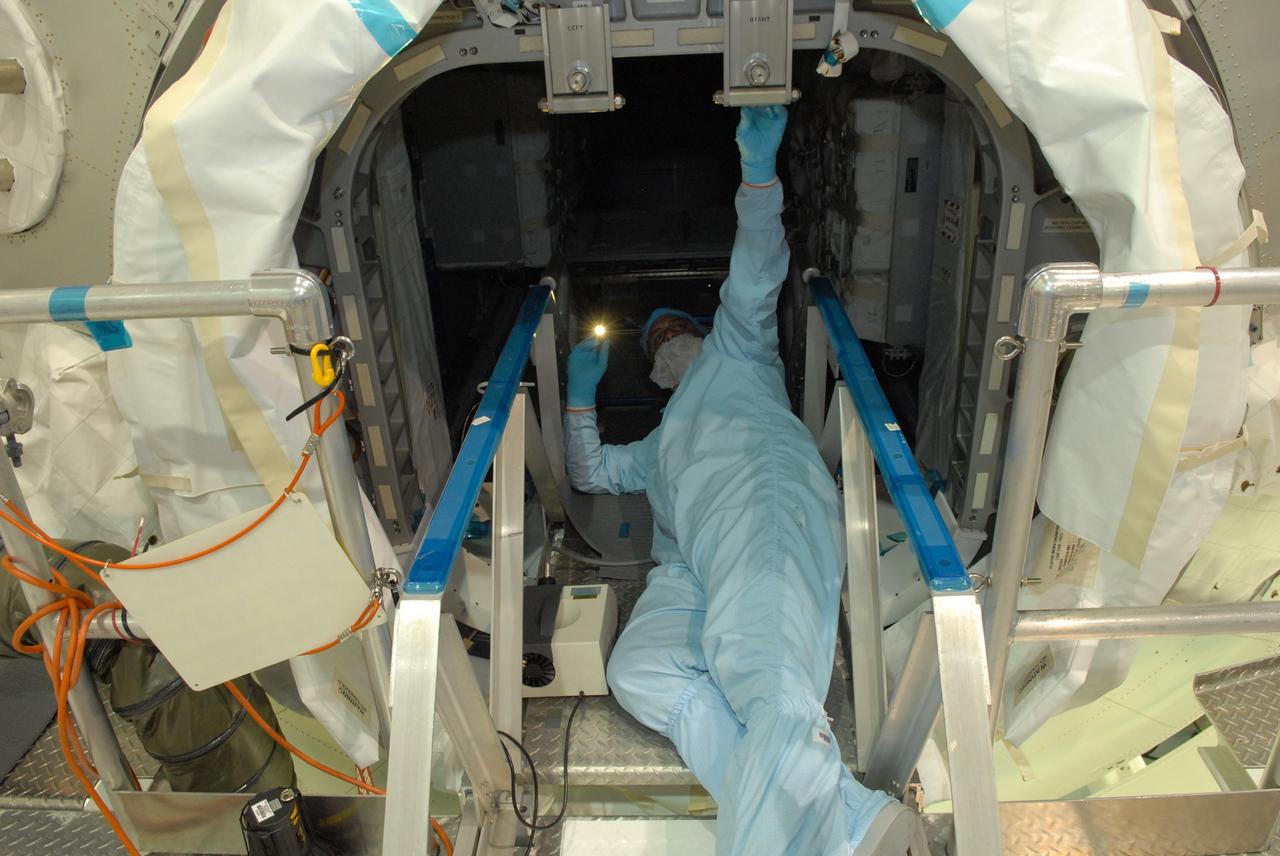 CAPE CANAVERAL, Fla. – In the Space Station Processing Facility at NASA's Kennedy Space Center in Florida, workers check the inside of the Multi-Purpose Logistics Module Leonardo before closing the hatch.  The module will carry science and storage racks on space shuttle Discovery's STS-128 mission to the International Space Station.  Launch of Discovery is targeted for Aug. 18.  Photo credit: NASA/Jim Grossmann