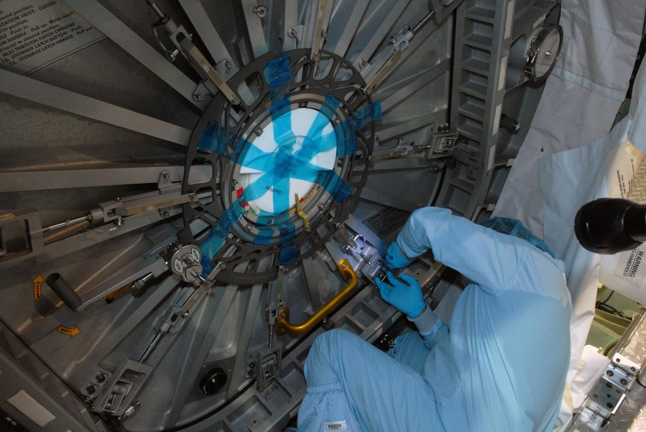 CAPE CANAVERAL, Fla. – In the Space Station Processing Facility at NASA's Kennedy Space Center in Florida, workers secure the door on the hatch to the Multi-Purpose Logistics Module Leonardo.  The module will carry science and storage racks on space shuttle Discovery's STS-128 mission to the International Space Station.  Launch of Discovery is targeted for Aug. 18.  Photo credit: NASA/Jim Grossmann