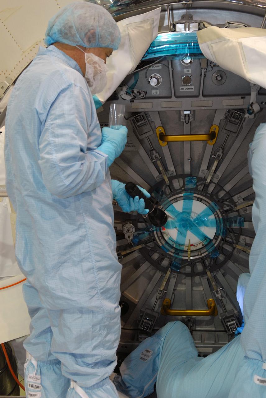 CAPE CANAVERAL, Fla. – In the Space Station Processing Facility at NASA's Kennedy Space Center in Florida, workers check the security of the door on the hatch to the Multi-Purpose Logistics Module Leonardo after its closing.  The module will carry science and storage racks on space shuttle Discovery's STS-128 mission to the International Space Station.  Launch of Discovery is targeted for Aug. 18.  Photo credit: NASA/Jim Grossmann