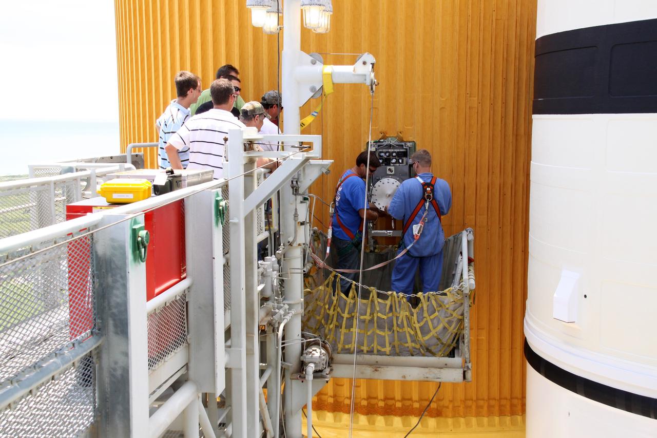 CAPE CANAVERAL, Fla. – On Launch Pad 39A at NASA's Kennedy Space Center in Florida, workers prepare to remove the 7-inch quick disconnect on the Ground Umbilical Carrier Plate, or GUCP, on space shuttle Endeavour's external fuel tank.  A hydrogen leak at the location during tanking for the STS-127 mission caused the launch attempts to be scrubbed on June 13 and June 17. The GUCP will be examined to determine the cause of the hydrogen leak and repaired. The GUCP is the overboard vent to the pad and the flame stack where the vented hydrogen is burned off. Endeavour's next launch attempt is targeted for July 11 at 7:39 p.m. EDT. Photo credit: NASA/Jack Pfaller