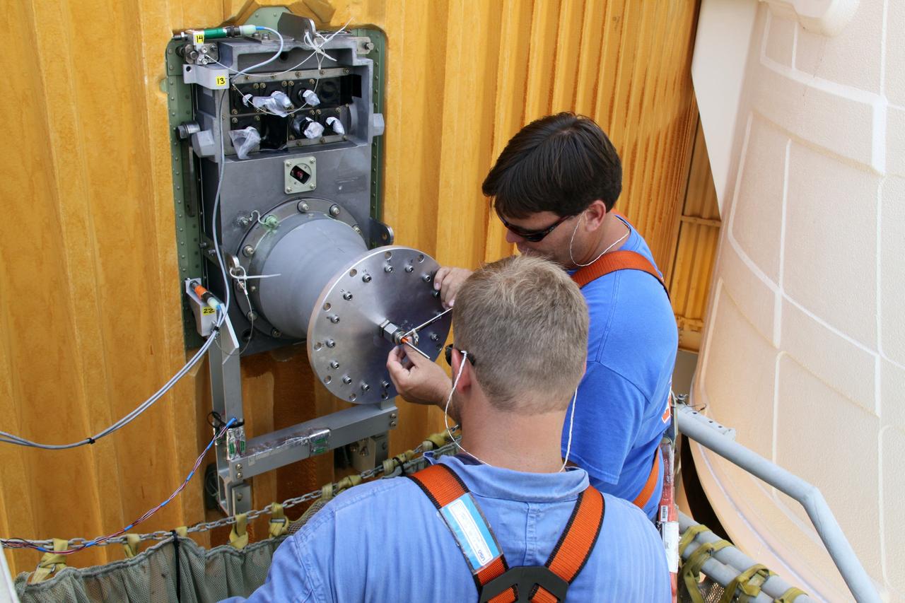CAPE CANAVERAL, Fla. – On Launch Pad 39A at NASA's Kennedy Space Center in Florida, workers remove the  7-inch quick disconnect on the Ground Umbilical Carrier Plate, or GUCP, on space shuttle Endeavour's external fuel tank.  A hydrogen leak at the location during tanking for the STS-127 mission caused the launch attempts to be scrubbed on June 13 and June 17. The GUCP will be examined to determine the cause of the hydrogen leak and repaired. The GUCP is the overboard vent to the pad and the flame stack where the vented hydrogen is burned off. Endeavour's next launch attempt is targeted for July 11 at 7:39 p.m. EDT. Photo credit: NASA/Jack Pfaller