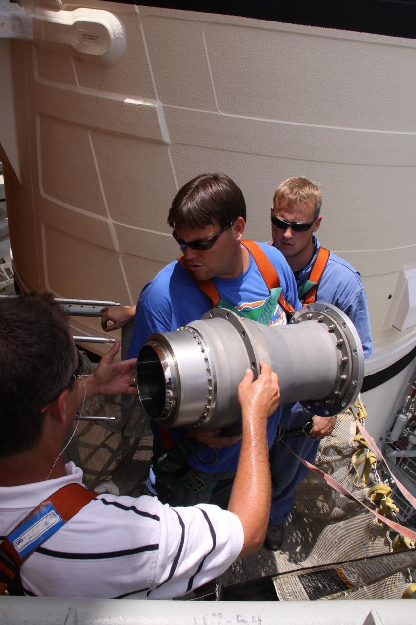 CAPE CANAVERAL, Fla. – On Launch Pad 39A at NASA's Kennedy Space Center in Florida,  workers remove the 7-inch quick disconnect from the Ground Umbilical Carrier Plate, or GUCP, on space shuttle Endeavour's external fuel tank. A hydrogen leak at the location during tanking for the STS-127 mission caused the launch attempts to be scrubbed on June 13 and June 17. The GUCP will be examined to determine the cause of the hydrogen leak and repaired. The GUCP is the overboard vent to the pad and the flame stack where the vented hydrogen is burned off. Endeavour's next launch attempt is targeted for July 11 at 7:39 p.m. EDT. Photo credit: NASA/Jack Pfaller