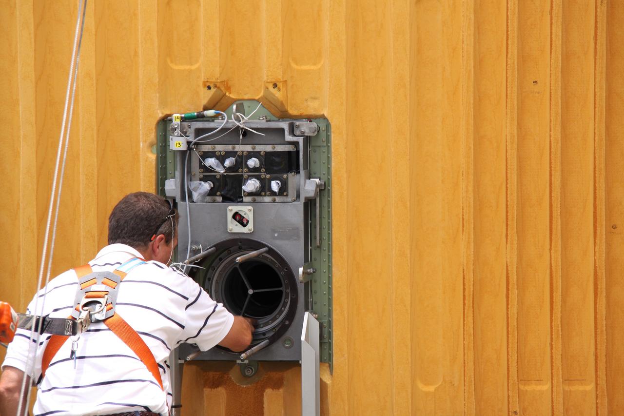 CAPE CANAVERAL, Fla. – On Launch Pad 39A at NASA's Kennedy Space Center in Florida,  a worker examines the location of the quick disconnect on the Ground Umbilical Carrier Plate, or GUCP, being removed from space shuttle Endeavour's external fuel tank. A hydrogen leak at the location during tanking for the STS-127 mission caused the launch attempts to be scrubbed on June 13 and June 17. The GUCP will be examined to determine the cause of the hydrogen leak and repaired. The GUCP is the overboard vent to the pad and the flame stack where the vented hydrogen is burned off. Endeavour's next launch attempt is targeted for July 11 at 7:39 p.m. EDT. Photo credit: NASA/Jack Pfaller