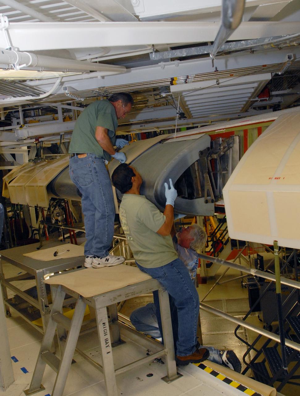 CAPE CANAVERAL, Fla. – In Orbiter Processing Facility 1 at NASA's Kennedy Space Center in Florida, workers remove the reinforced-carbon carbon, or RCC, panels from the wing leading edge on space shuttle Atlantis. The structural edge of the wing (area of red and green behind the panels) will undergo spar corrosion inspection to verify the structural integrity of the wing. The RCC panels will be placed in protective coverings until the inspection is complete. Atlantis will make the 31st flight to the International Space Station for the STS-129 mission, targeted for launch on Nov. 12. Photo credit: NASA/Tim Jacobs
