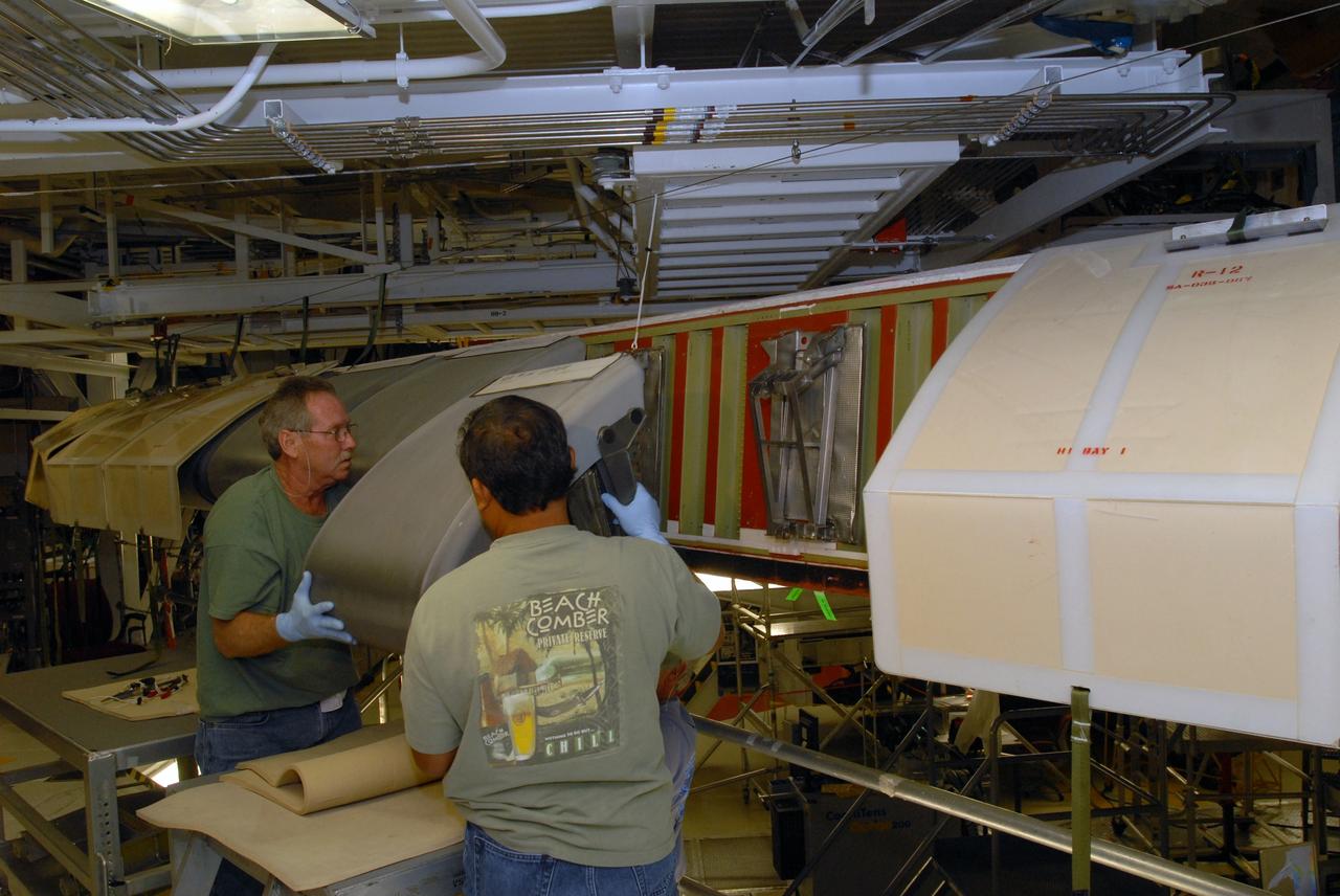 CAPE CANAVERAL, Fla. – In Orbiter Processing Facility 1 at NASA's Kennedy Space Center in Florida, workers remove the reinforced-carbon carbon, or RCC, panels from the wing leading edge on space shuttle Atlantis. The structural edge of the wing (area of red and green behind the panels) will undergo spar corrosion inspection to verify the structural integrity of the wing. The RCC panels will be placed in protective coverings until the inspection is complete. Atlantis will make the 31st flight to the International Space Station for the STS-129 mission, targeted for launch on Nov. 12. Photo credit: NASA/Tim Jacobs