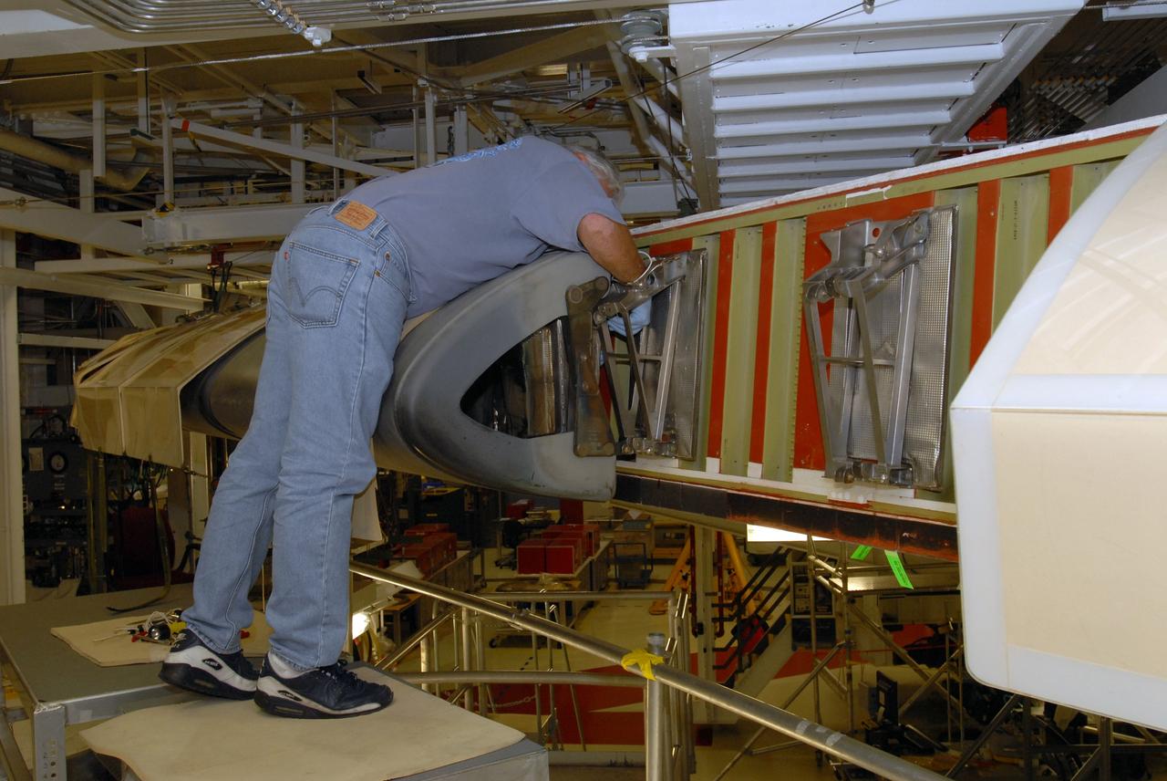 CAPE CANAVERAL, Fla. – In Orbiter Processing Facility 1 at NASA's Kennedy Space Center in Florida, a worker removes a reinforced-carbon carbon, or RCC, panel from the wing leading edge on space shuttle Atlantis. The structural edge of the wing (area of red and green behind the panels) will undergo spar corrosion inspection to verify the structural integrity of the wing. The RCC panels will be placed in protective coverings until the inspection is complete. Atlantis will make the 31st flight to the International Space Station for the STS-129 mission, targeted for launch on Nov. 12. Photo credit: NASA/Tim Jacobs