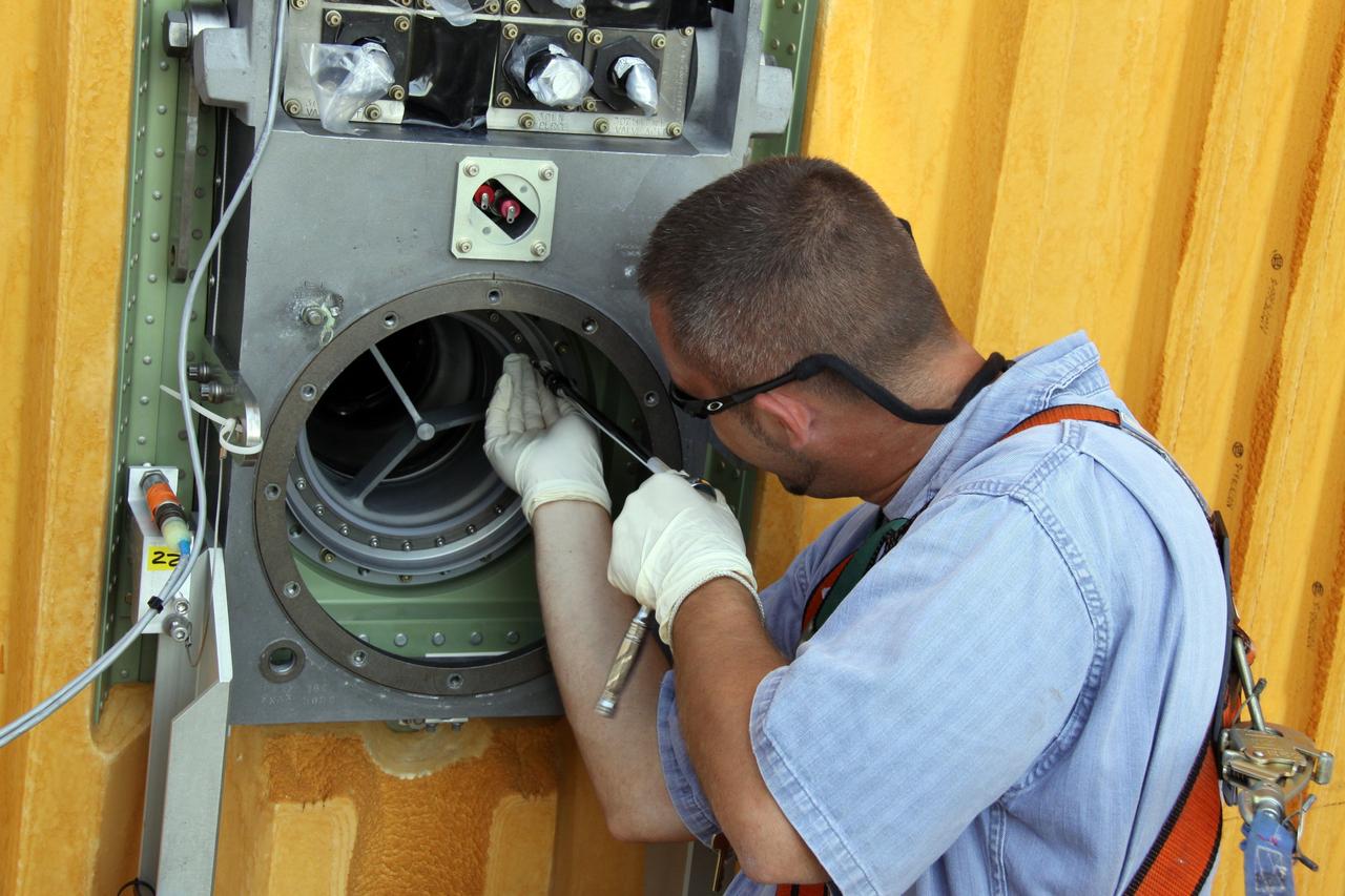 CAPE CANAVERAL, Fla. – On Launch Pad 39A at NASA's Kennedy Space Center in Florida, a worker removes the seal from the Ground Umbilical Carrier Plate, or GUCP, on space shuttle Endeavour's external fuel tank. A hydrogen leak at the location during tanking for the STS-127 mission caused the launch attempts to be scrubbed on June 13 and June 17. The GUCP will be examined to determine the cause of the hydrogen leak and repaired. The GUCP is the overboard vent to the pad and the flame stack where the vented hydrogen is burned off. Endeavour's next launch attempt is targeted for July 11 at 7:39 p.m. EDT. Photo credit: NASA/Jack Pfaller