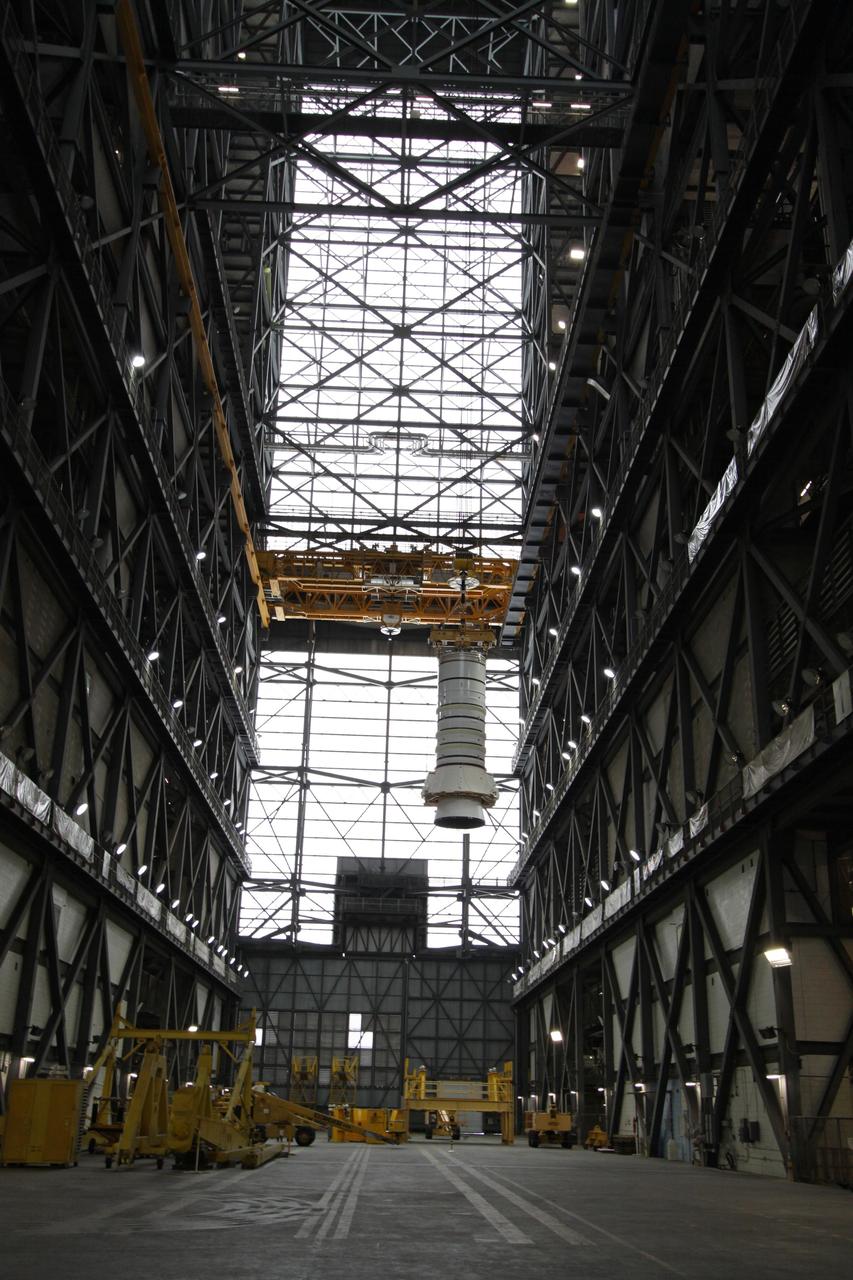 CAPE CANAVERAL, Fla. – In the Vehicle Assembly Building at NASA's Kennedy Space Center in Florida, the Ares I-X aft booster segment with the aft skirt is lifted across the VAB transfer aisle. The stack will be hoisted into the upper regions of the VAB and lowered onto the mobile launch platform in High Bay 3. This is the start of the buildup of the Ares I-X launch vehicle for the flight test targeted for no earlier than Aug. 30. Part of the Constellation Program, the Ares I-X is the test vehicle for the Ares I, which is the essential core of a space transportation system that eventually will carry crewed missions back to the moon, on to Mars and out into the solar system. Photo credit: NASA/Jack Pfaller