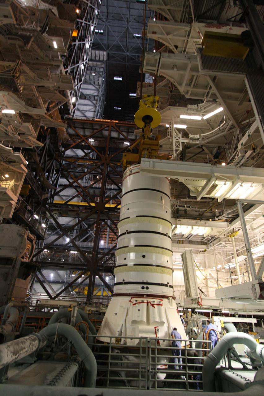 CAPE CANAVERAL, Fla. – In the Vehicle Assembly Building at NASA's Kennedy Space Center in Florida, workers keep watch as the Ares I-X aft booster segment with the aft skirt is lowered toward the mobile launch platform in High Bay 3. This is the start of the buildup of the Ares I-X launch vehicle for the flight test targeted for no earlier than Aug. 30. Part of the Constellation Program, the Ares I-X is the test vehicle for the Ares I, which is the essential core of a space transportation system that eventually will carry crewed missions back to the moon, on to Mars and out into the solar system. Photo credit: NASA/Jack Pfaller
