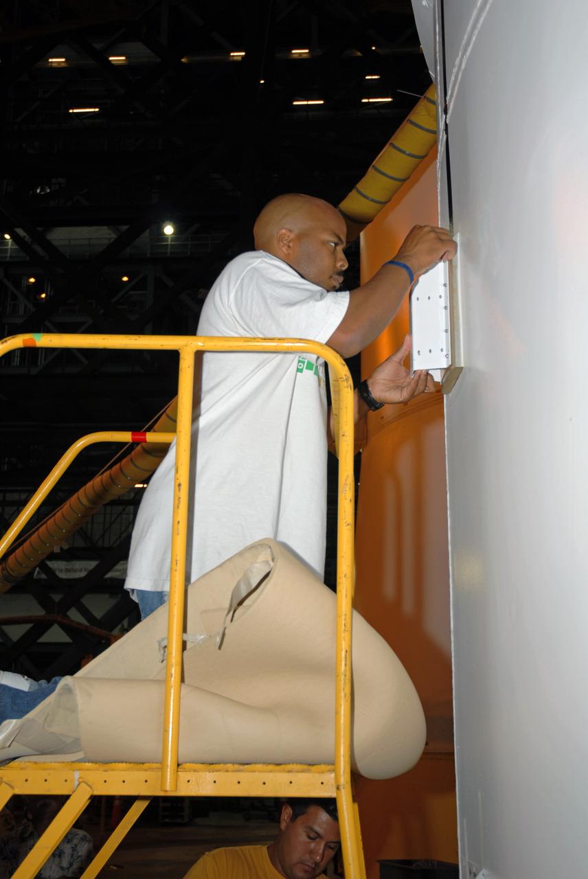 CAPE CANAVERAL, Fla. – In the Vehicle Assembly Building's High Bay 4 at NASA's Kennedy Space Center in Florida, technician Troy Merrick, with United Space Alliance, installs a video camera on the side of the Ares I-X segments 6 and 7. The downward facing camera will provide live video during launch. Part of the Constellation Program, the Ares I-X is the test vehicle for the Ares I, which is the essential core of a space transportation system that eventually will carry crewed missions back to the moon, on to Mars and out into the solar system . The Ares I-X flight test is targeted for no earlier than Aug. 30. Photo credit: NASA/Jack Pfaller