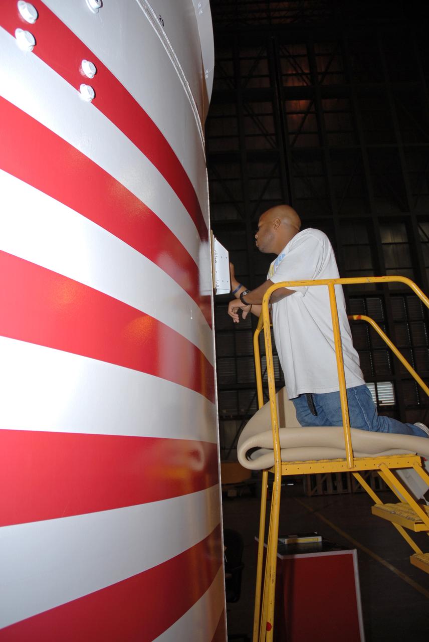 CAPE CANAVERAL, Fla. – In the Vehicle Assembly Building's High Bay 4 at NASA's Kennedy Space Center in Florida, technician Troy Merrick, with United Space Alliance, installs a video camera on the side of the Ares I-X segments 6 and 7. The downward facing camera will provide live video during launch. Part of the Constellation Program, the Ares I-X is the test vehicle for the Ares I, which is the essential core of a space transportation system that eventually will carry crewed missions back to the moon, on to Mars and out into the solar system . The Ares I-X flight test is targeted for no earlier than Aug. 30. Photo credit: NASA/Jack Pfaller