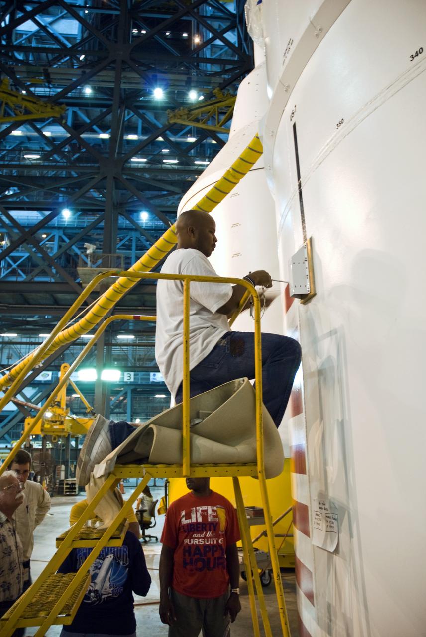 CAPE CANAVERAL, Fla. – In the Vehicle Assembly Building's High Bay 4 at NASA's Kennedy Space Center in Florida, technician Troy Merrick, with United Space Alliance, finishes installing a video camera on the side of the Ares I-X segments 6 and 7. The downward facing camera will provide live video during launch. Part of the Constellation Program, the Ares I-X is the test vehicle for the Ares I, which is the essential core of a space transportation system that eventually will carry crewed missions back to the moon, on to Mars and out into the solar system . The Ares I-X flight test is targeted for no earlier than Aug. 30. Photo credit: NASA/Jack Pfaller