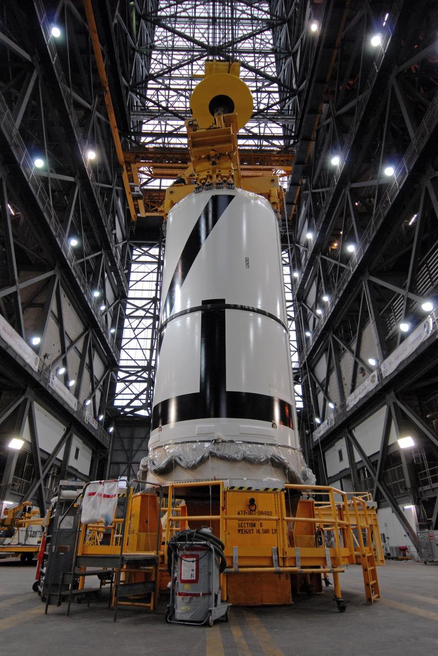 CAPE CANAVERAL, Fla. – In the Vehicle Assembly Building's transfer aisle at NASA's Kennedy Space Center in Florida, an overhead crane is attached to the Ares I-X aft center booster segment. The segment will be lifted and then lowered into High Bay 3 for attachment to the aft booster segment with the aft skirt. Part of the Constellation Program, the Ares I-X is the test vehicle for the Ares I, which is the essential core of a space transportation system that eventually will carry crewed missions back to the moon, on to Mars and out into the solar system . The flight test of the Ares I-X is targeted for no earlier than Aug. 30. Photo credit: NASA/Tim Jacobs