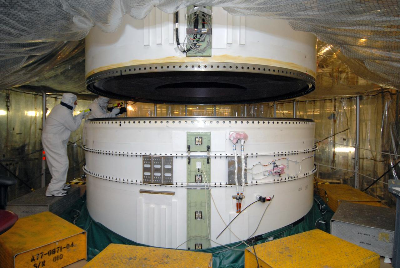 CAPE CANAVERAL, Fla. – In the Vehicle Assembly Building's High Bay 3 at NASA's Kennedy Space Center in Florida, the Ares I-X aft center booster segment is lowered for attachment to the aft booster and skirt. Part of the Constellation Program, the Ares I-X is the test vehicle for the Ares I, which is the essential core of a space transportation system that eventually will carry crewed missions back to the moon, on to Mars and out into the solar system . The flight test of the Ares I-X is targeted for no earlier than Aug. 30. Photo credit: NASA/Tim Jacobs