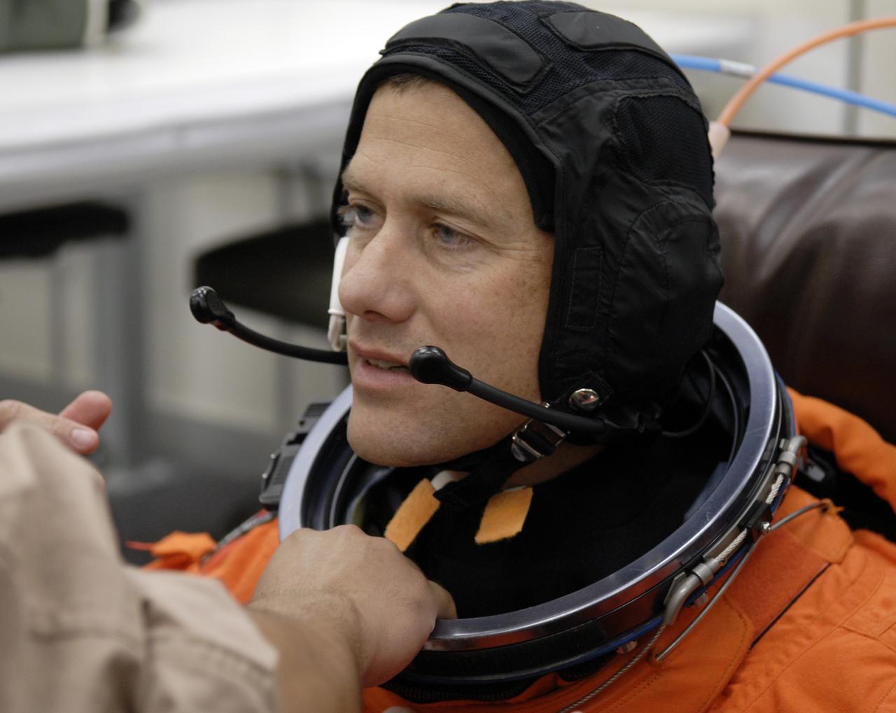 CAPE CANAVERAL, Fla. – In the Operations and Checkout Building at NASA's Kennedy Space Center in Florida, STS-127 crew members put on their launch-and-entry suits before heading to the Astrovan for the 3.4-mile drive to Launch Pad 39A. Seen here is Mission Specialist Tom Marshburn, who is checking his headset. He is making his first shuttle flight. At the pad, Marshburn and the other crew members will complete their suitup and enter space shuttle Endeavour for the 7:13 p.m. EDT liftoff. This is the fourth launch attempt for the STS-127 mission. The first two launch attempts on June 13 and June 17 were scrubbed when a hydrogen gas leak occurred during tanking due to a misaligned Ground Umbilical Carrier Plate. Mission managers also decided to delay tanking on July 11 for a launch attempt later in the day to allow engineers and safety personnel time to analyze data captured during lightning strikes near the pad on July 10. Endeavour will deliver the Japanese Experiment Module's Exposed Facility, or JEM-EF, and the Experiment Logistics Module-Exposed Section, or ELM-ES, in the final of three flights dedicated to the assembly of the Japan Aerospace Exploration Agency's Kibo laboratory complex on the International Space Station. STS-127 is the 29th flight for the assembly of the space station. Photo credit: NASA/Kim Shiflett