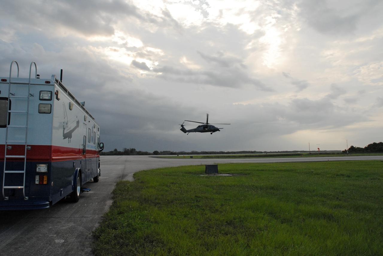 CAPE CANAVERAL, Fla. – A military helicopter hovers near the Shuttle Landing Facility runway at NASA's Kennedy Space Center in Florida.  It joins the convoy command and SCAPE vehicles that are in position in the event of a return-to-landing-site is needed after launch of space shuttle Endeavour on the STS-127 mission. This is the fourth launch attempt for the STS-127 mission. The first two launch attempts on June 13 and June 17 were scrubbed when a hydrogen gas leak occurred during tanking due to a misaligned Ground Umbilical Carrier Plate. Mission managers also decided to delay tanking on July 11 for a launch attempt later in the day to allow engineers and safety personnel time to analyze data captured during lightning strikes near the pad on July 10. Endeavour will deliver the Japanese Experiment Module's Exposed Facility, or JEM-EF, and the Experiment Logistics Module-Exposed Section, or ELM-ES, in the final of three flights dedicated to the assembly of the Japan Aerospace Exploration Agency's Kibo laboratory complex on the International Space Station.  STS-127 is the 29th flight for the assembly of the space.   Photo credit: NASA/Jack Pfaller