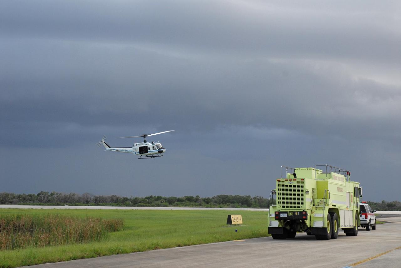 CAPE CANAVERAL, Fla. – A NASA Security helicopter hovers near the Shuttle Landing Facility runway at NASA's Kennedy Space Center in Florida.  It joins the convoy command and SCAPE vehicles that are in position in the event of a return-to-landing-site is needed after launch of space shuttle Endeavour on the STS-127 mission. This is the fourth launch attempt for the STS-127 mission. The first two launch attempts on June 13 and June 17 were scrubbed when a hydrogen gas leak occurred during tanking due to a misaligned Ground Umbilical Carrier Plate. Mission managers also decided to delay tanking on July 11 for a launch attempt later in the day to allow engineers and safety personnel time to analyze data captured during lightning strikes near the pad on July 10. Endeavour will deliver the Japanese Experiment Module's Exposed Facility, or JEM-EF, and the Experiment Logistics Module-Exposed Section, or ELM-ES, in the final of three flights dedicated to the assembly of the Japan Aerospace Exploration Agency's Kibo laboratory complex on the International Space Station.  STS-127 is the 29th flight for the assembly of the space.   Photo credit: NASA/Jack Pfaller