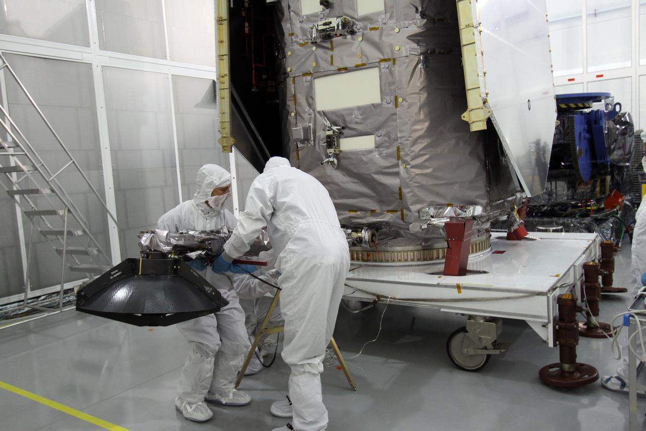 CAPE CANAVERAL, Fla. – Engineers at Astrotech Space Operations in Titusville, Fla., lower the high-gain antenna on the Solar Dynamics Observatory to gain access to the battery compartment for installation of the flight battery. SDO is the first space weather research network mission in NASA's Living With a Star Program. The spacecraft's long-term measurements will give solar scientists in-depth information about changes in the sun's magnetic field and insight into how they affect Earth. In preparation for its anticipated November launch, engineers will perform a battery of comprehensive tests to ensure SDO can withstand the stresses and vibrations of the launch itself, as well as what it will encounter in the space environment after launch. Photo credit: NASA/Jack Pfaller