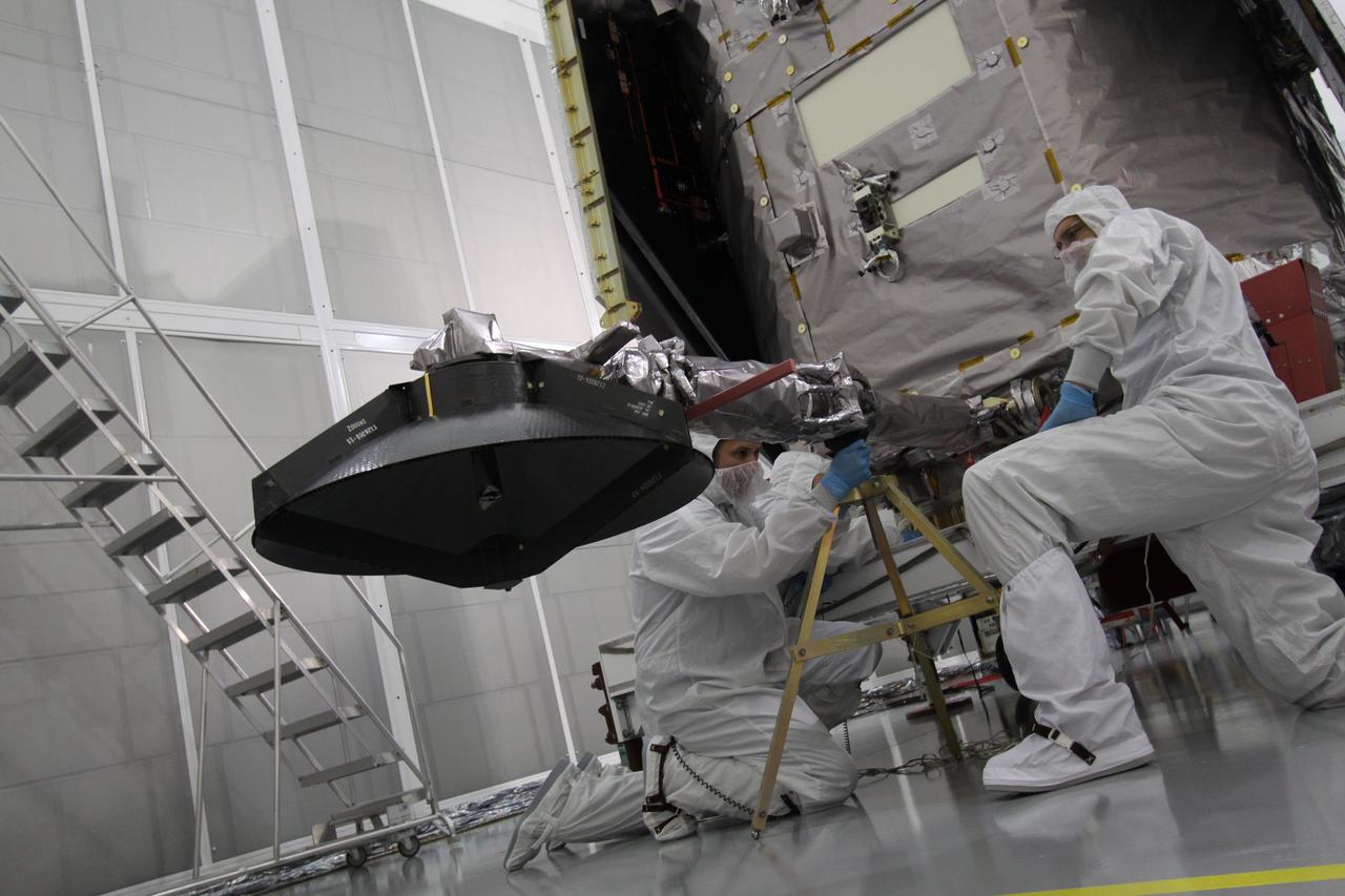 CAPE CANAVERAL, Fla. – Engineers at Astrotech Space Operations in Titusville, Fla., support the high-gain antenna lowered to allow access to the battery compartment for installation of the flight battery. SDO is the first space weather research network mission in NASA's Living With a Star Program. The spacecraft's long-term measurements will give solar scientists in-depth information about changes in the sun's magnetic field and insight into how they affect Earth. In preparation for its anticipated November launch, engineers will perform a battery of comprehensive tests to ensure SDO can withstand the stresses and vibrations of the launch itself, as well as what it will encounter in the space environment after launch. Photo credit: NASA/Jack Pfaller