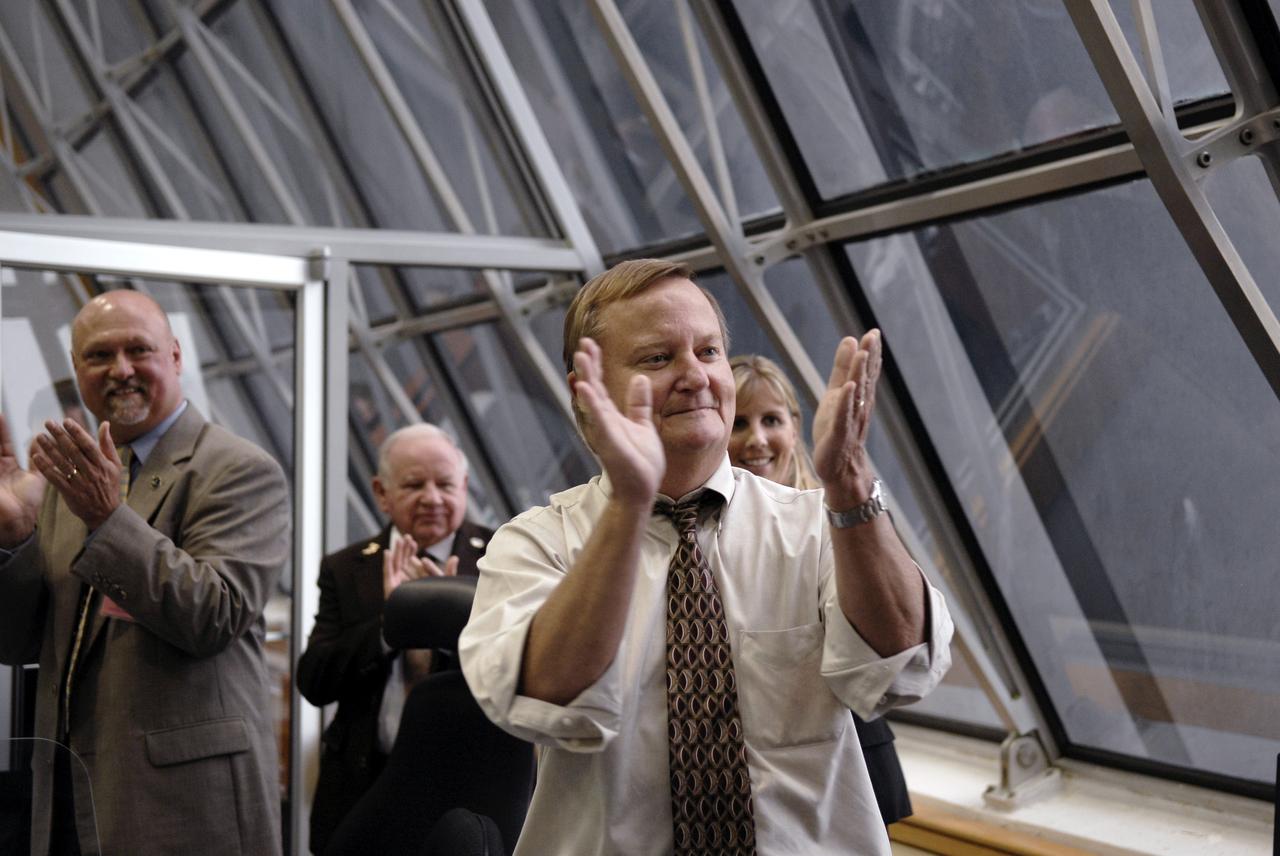 CAPE CANAVERAL, Fla. – In the Firing Room at NASA's Kennedy Space Center in Florida, the successful launch of space shuttle Endeavour is applauded by Shuttle Launch Director Mike Leinbach (foreground), NASA Public Affairs Officer Mike Curie (left) and Endeavour Flow Director Dana Hutcherson  (right). Liftoff was on-time at 6:03 p.m. EDT. Today was the sixth launch attempt for the STS-127 mission.  The launch was scrubbed on June 13 and June 17 when a hydrogen gas leak occurred during tanking due to a misaligned Ground Umbilical Carrier Plate.  The mission was postponed July 11, 12 and 13 due to weather conditions near the Shuttle Landing Facility at Kennedy that violated rules for launching, and lightning issues. Endeavour will deliver the Japanese Experiment Module's Exposed Facility and the Experiment Logistics Module-Exposed Section in the final of three flights dedicated to the assembly of the Japan Aerospace Exploration Agency's Kibo laboratory complex on the International Space Station.   Photo credit: NASA/Kim Shiflett