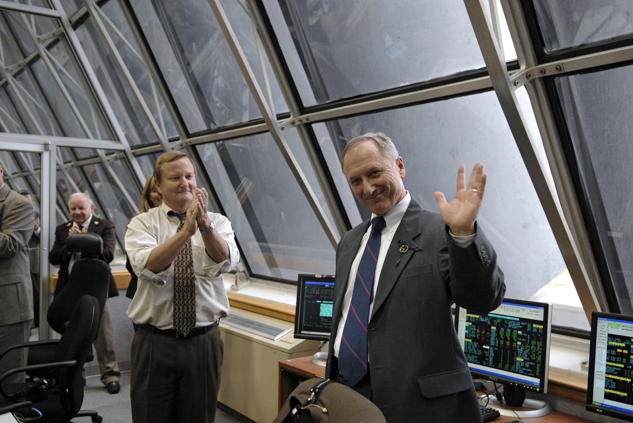 CAPE CANAVERAL, Fla. – In the Firing Room at NASA's Kennedy Space Center in Florida, Shuttle Launch Director Mike Leinbach  (center) applauds STS-127 Shuttle Launch Director Pete Nickolenko for his role in the successful launch of space shuttle Endeavour on the STS-127 mission.  Liftoff was on-time at 6:03 p.m. EDT.  Today was the sixth launch attempt for the STS-127 mission.  The launch was scrubbed on June 13 and June 17 when a hydrogen gas leak occurred during tanking due to a misaligned Ground Umbilical Carrier Plate.  The mission was postponed July 11, 12 and 13 due to weather conditions near the Shuttle Landing Facility at Kennedy that violated rules for launching, and lightning issues. Endeavour will deliver the Japanese Experiment Module's Exposed Facility and the Experiment Logistics Module-Exposed Section in the final of three flights dedicated to the assembly of the Japan Aerospace Exploration Agency's Kibo laboratory complex on the International Space Station.   Photo credit: NASA/Kim Shiflett