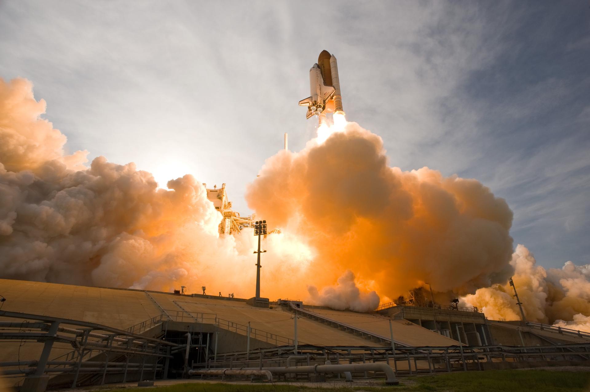 Space shuttle Endeavour launches in a fiery plume of smoke and steam